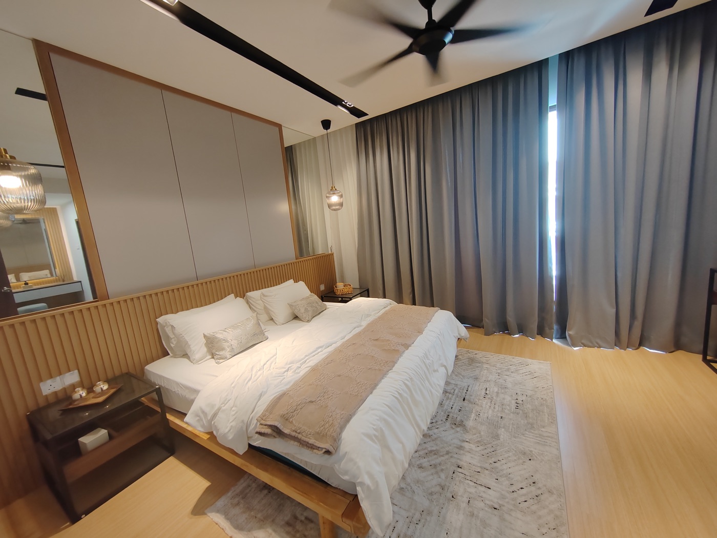 Foto bilik tidur utama rumah contoh Adenia berlantai kayu lamina dengan katil dan langsir kelabu