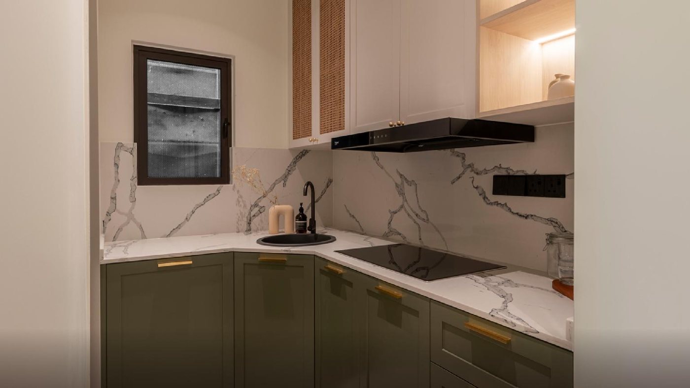 Foto show unit Ara Residences Jenis B: dapur bentuk L dengan kabinet hijau, hud dan jubin corak marmar