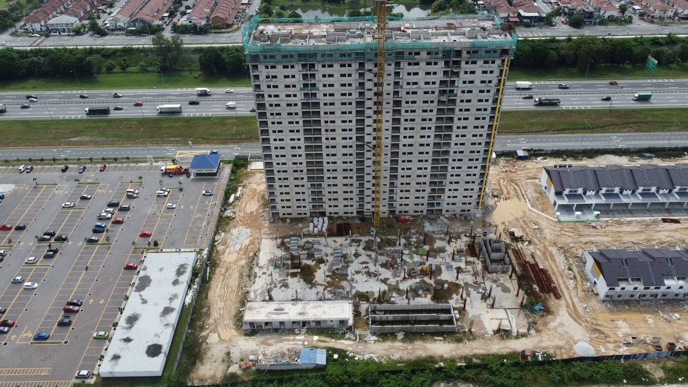 Foto udara sebenar blok apartmen BSP Sutera dalam pembinaan dengan kren menara, bersebelahan lebuh raya, November 2025