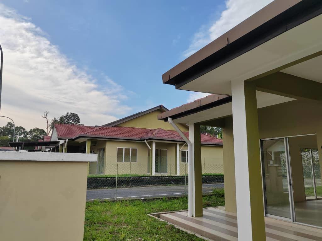 Foto sebenar rumah berkembar setingkat: anjung berbumbung, pintu gelangsar kaca dan halaman sisi berumput