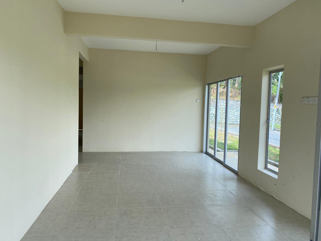 Foto sebenar ruang tamu rumah berkembar: ruang kosong berlantai jubin dengan pintu gelangsar dan tingkap tinggi
