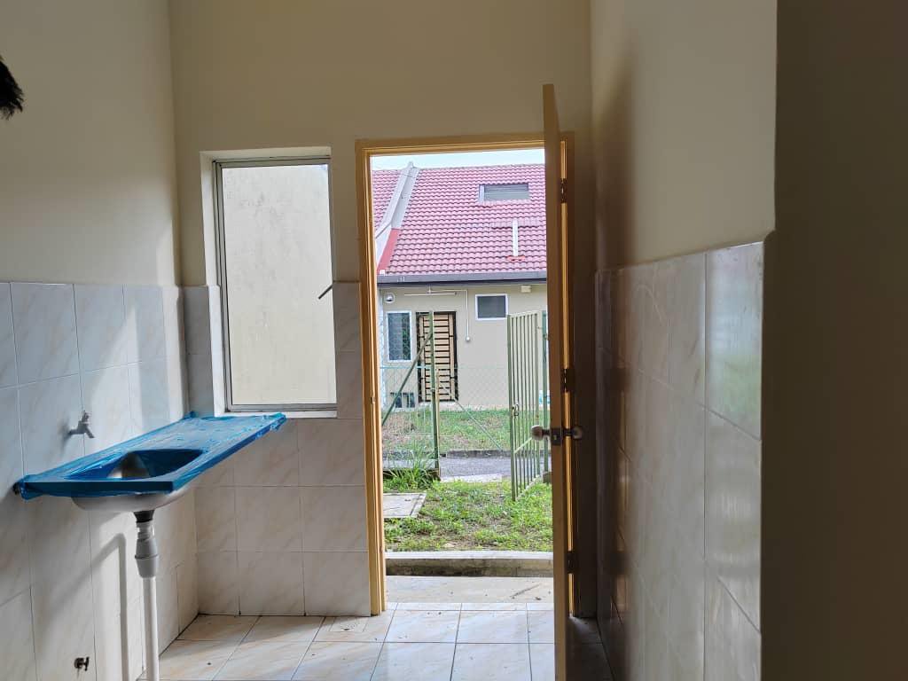 Foto sebenar dapur rumah teres: sinki asas, jubin dinding separuh tinggi dan pintu ke halaman belakang
