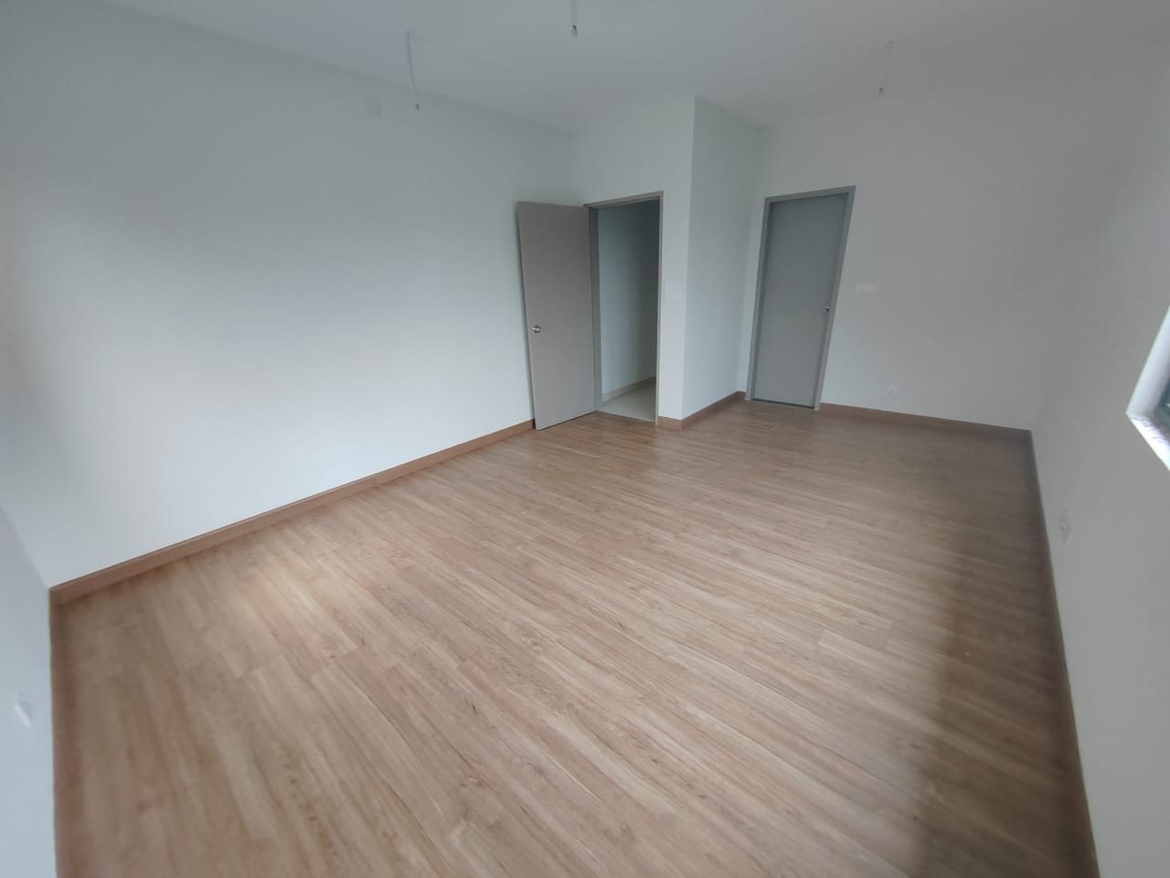 Foto sebenar bilik tidur utama unit bawah Elegan Residensi yang kosong dengan lantai berkemasan kayu