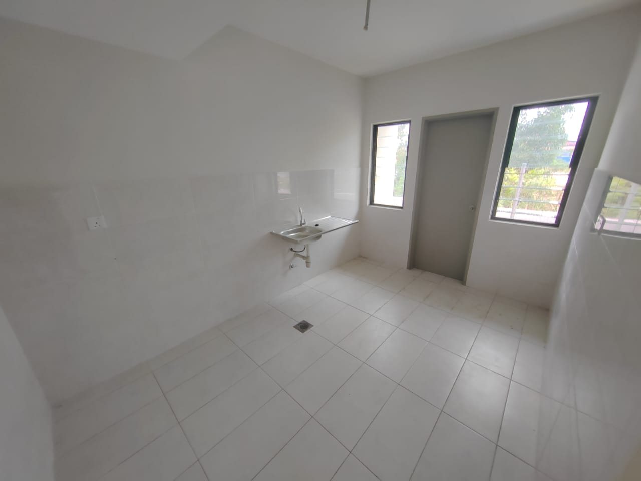 Foto sebenar dapur unit bawah Elegan Residensi yang kosong dengan jubin dinding, sinki dan pintu ke yard