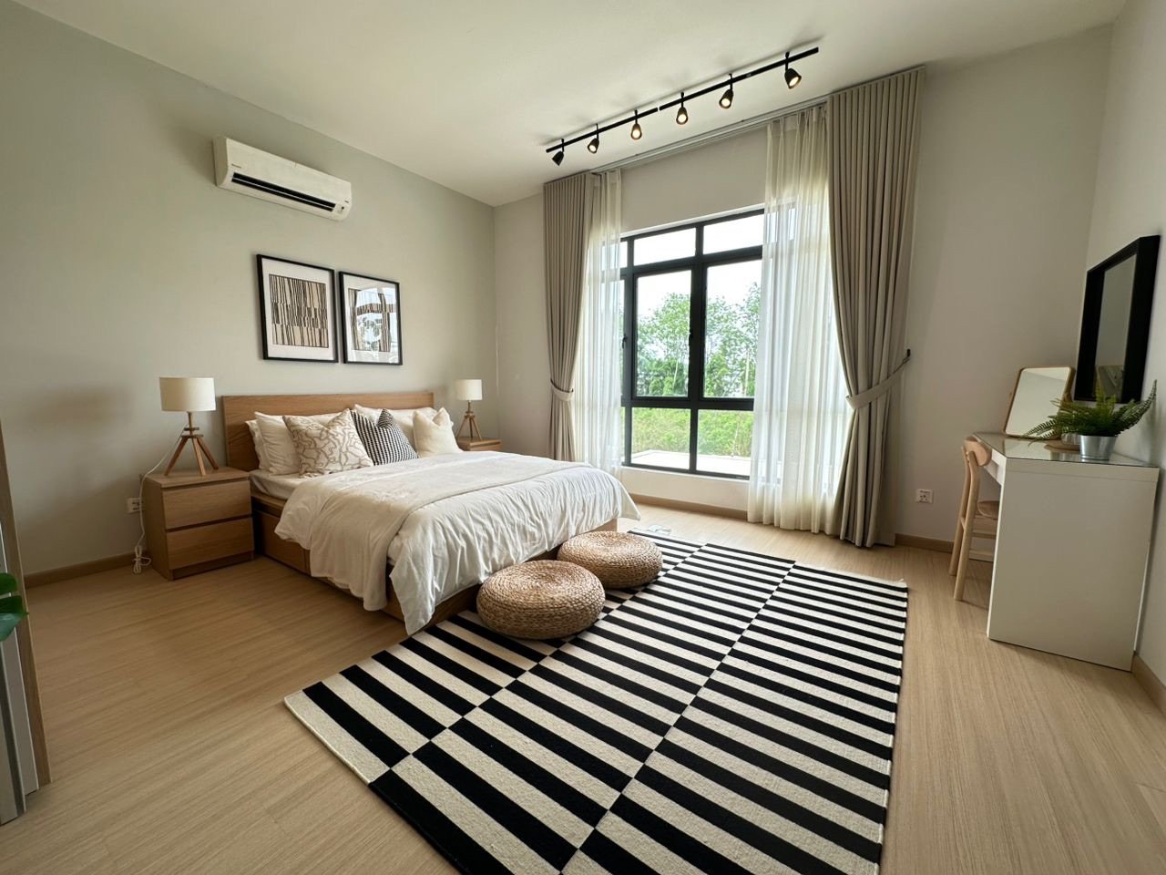 Foto rumah contoh bilik tidur utama dengan katil queen dan penghawa dingin