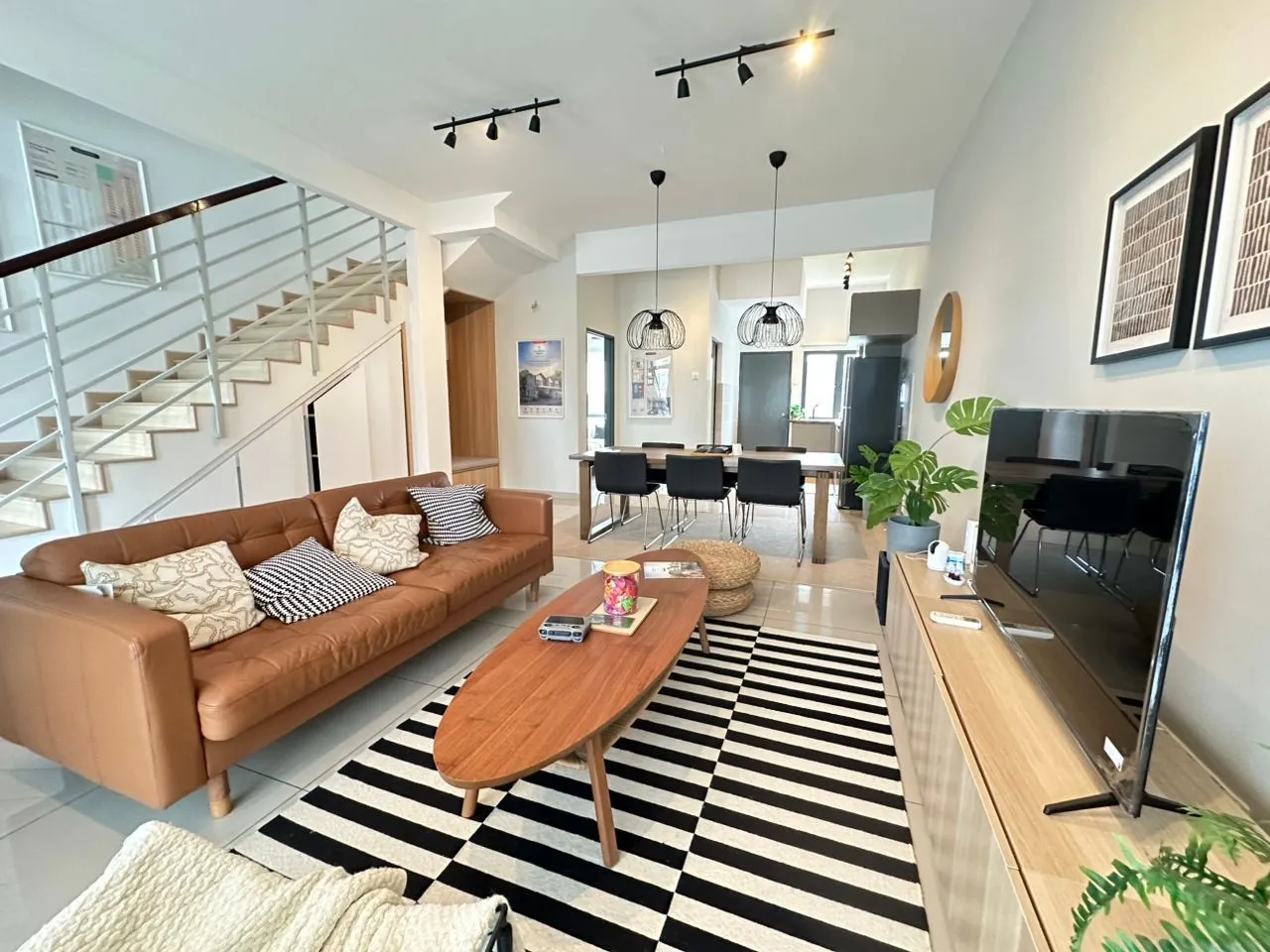 Foto rumah contoh Taman Idaman Jiwa 1: ruang tamu dan ruang makan terbuka dengan tangga, sofa dan hiasan