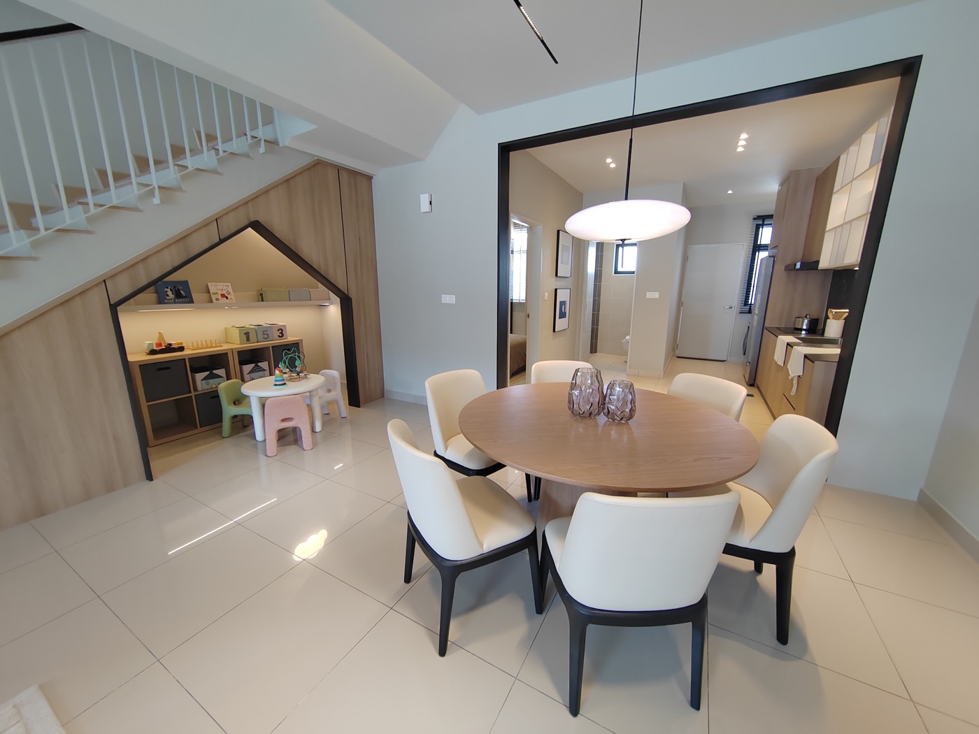 Foto rumah contoh Kamelia: ruang makan dengan meja bulat di sebelah tangga