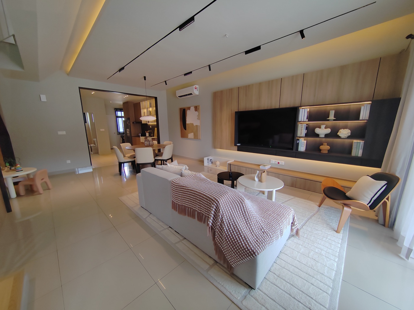 Foto rumah contoh Kamelia: ruang tamu dengan sofa dan kabinet TV