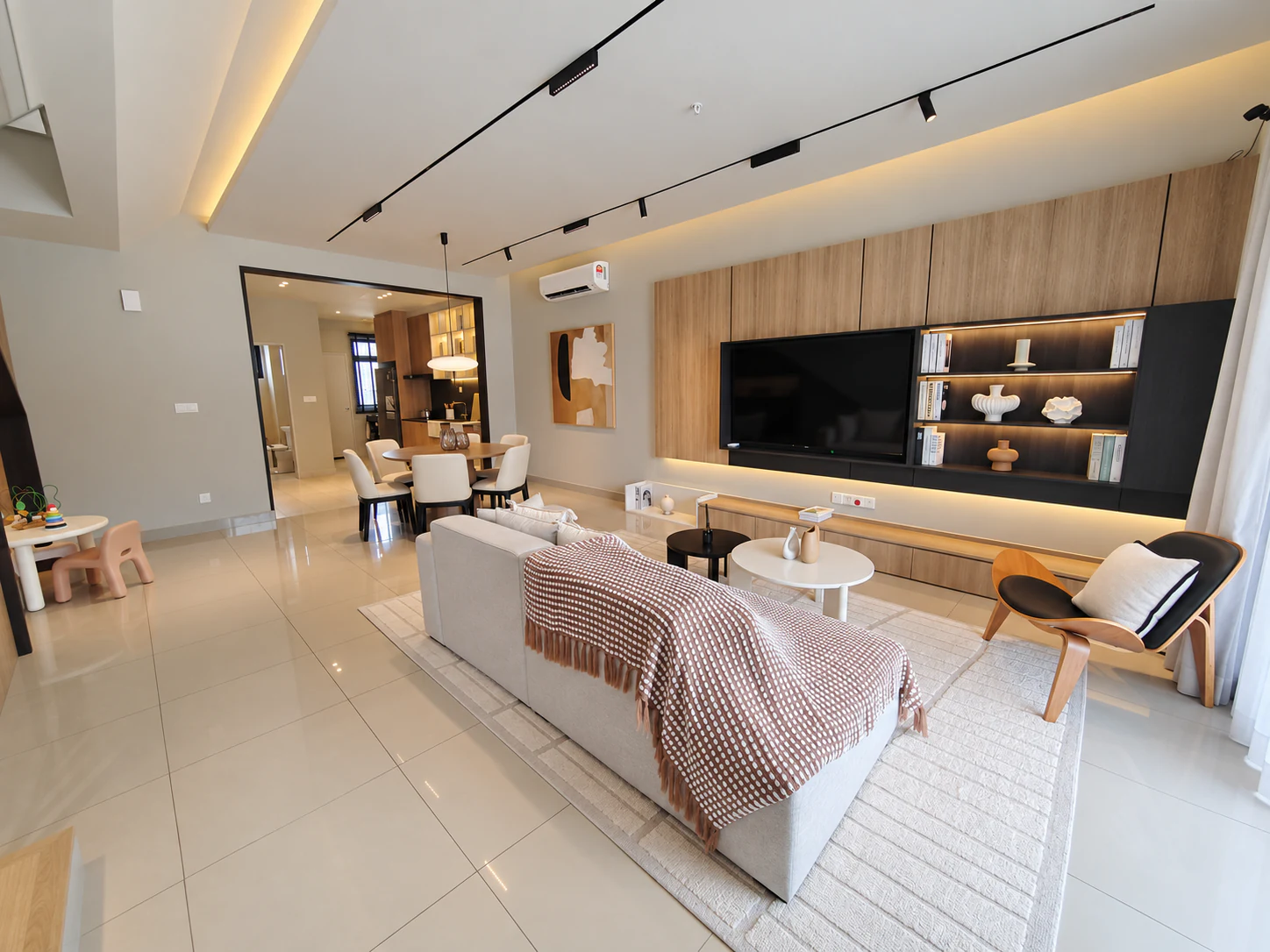 Foto rumah contoh Kamelia: ruang tamu dengan sofa dan kabinet TV