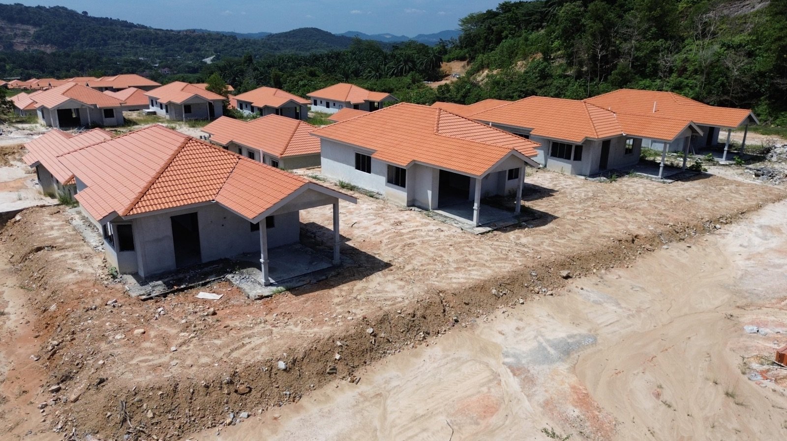 Foto dron deretan banglo setingkat berbumbung jingga dalam pembinaan di Desa 3 dan Desa 4