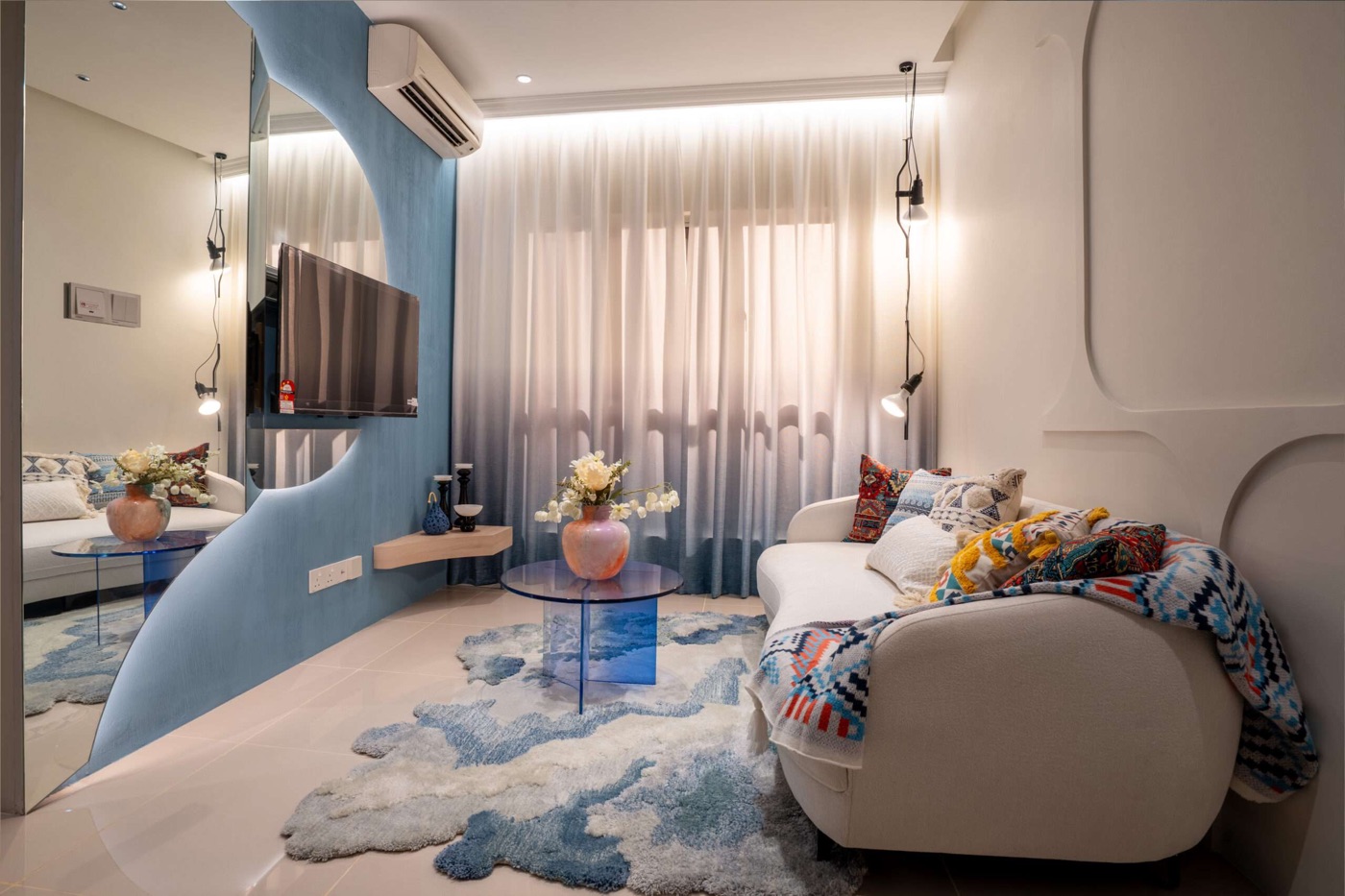 Foto ruang tamu unit Jenis B yang dihias dengan sofa putih dan dinding biru