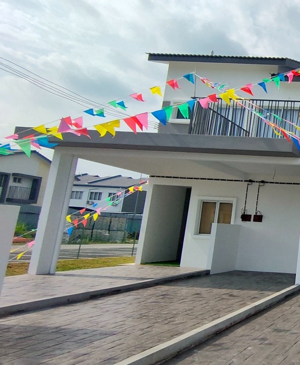 Foto bahagian hadapan bangunan unit contoh townhouse dua tingkat dengan anjung kereta dan balkoni di atas