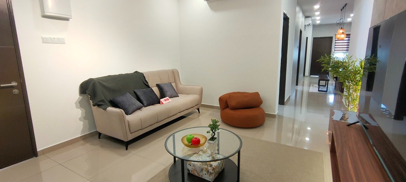 Foto ruang tamu unit contoh atas dengan sofa kelabu dan meja kopi kaca