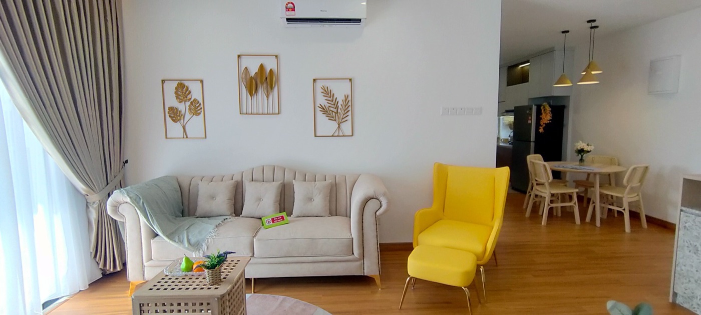 Foto ruang tamu unit contoh bawah Nemesia Residence dengan sofa putih, kerusi kuning dan lukisan dinding