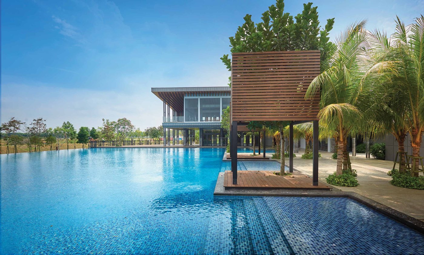 Foto kolam renang panjang The Club Rimbayu dengan pavilion kayu dan bangunan kelab di belakang