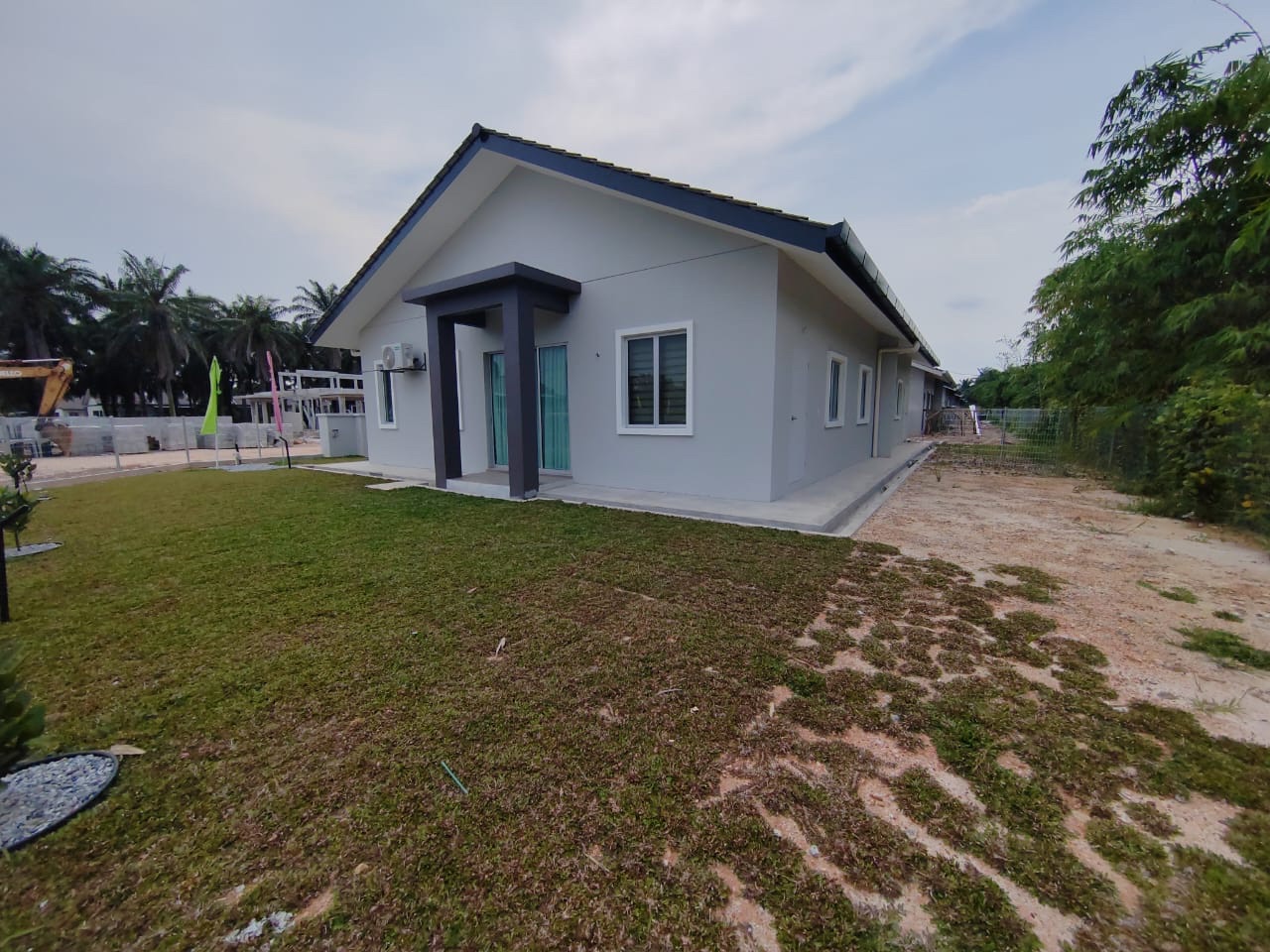 Foto sebenar sisi rumah contoh Semi-D dengan laman berumput yang luas