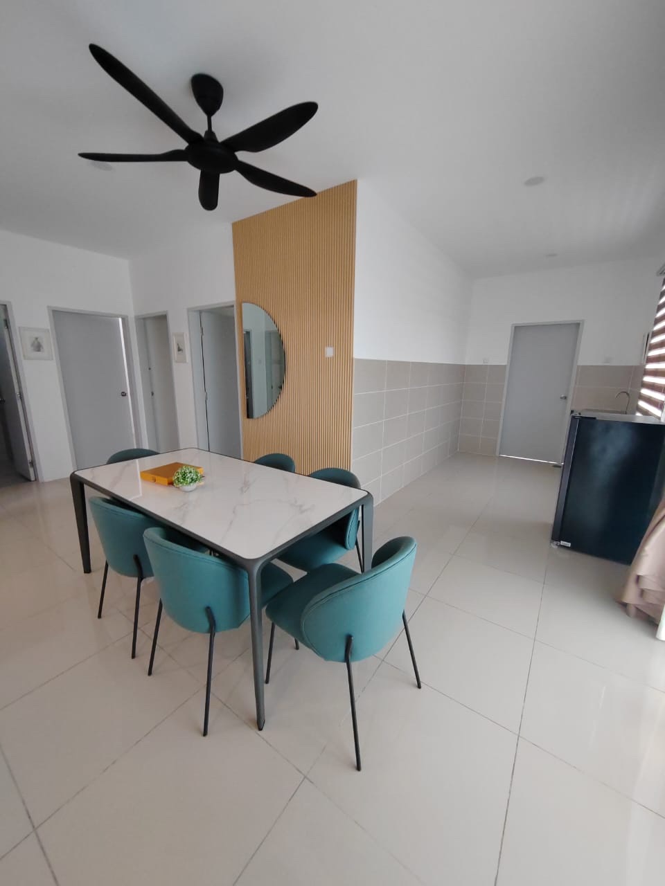 Foto ruang makan rumah contoh Semi-D dengan meja putih dan kerusi biru