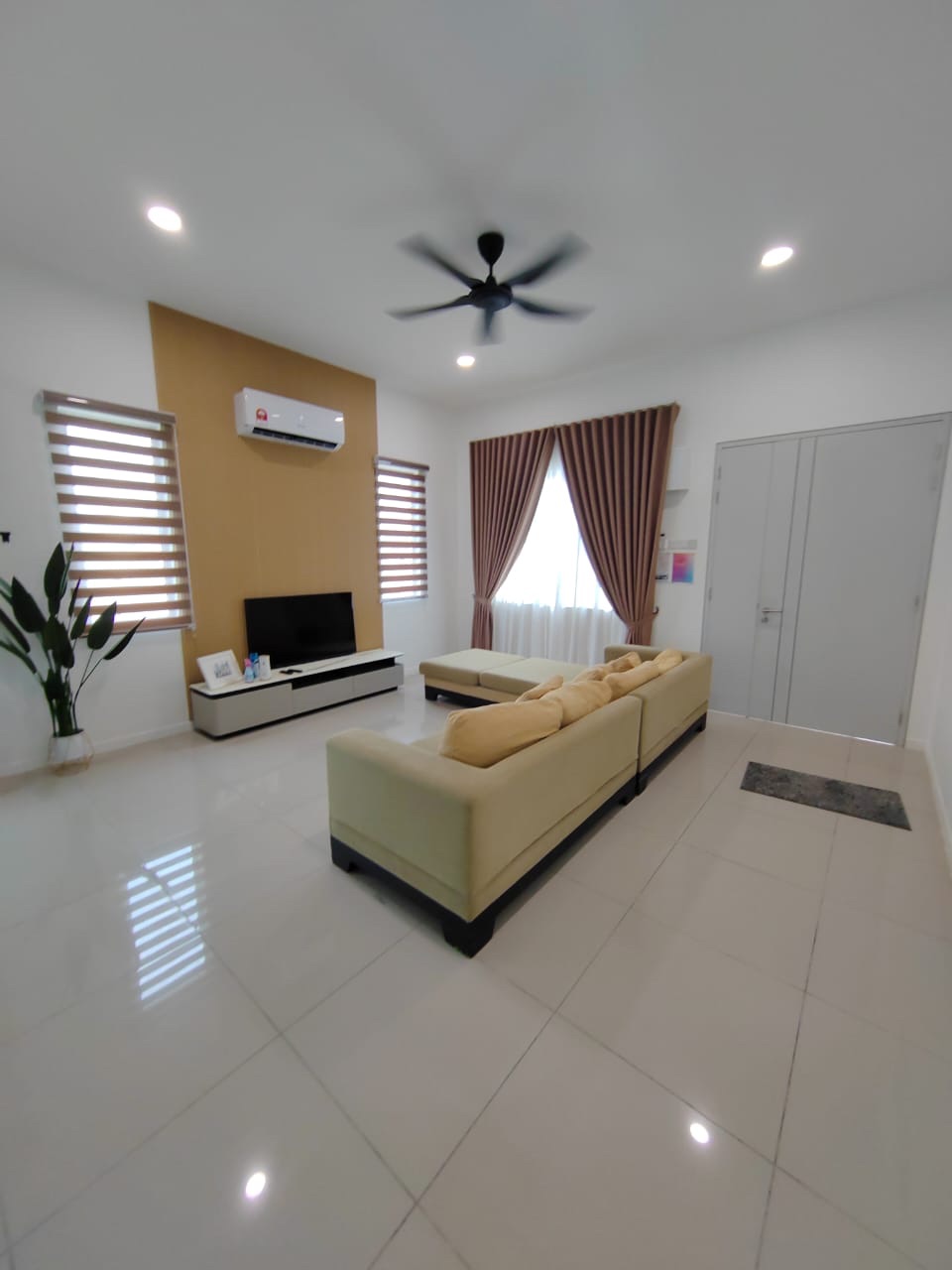 Foto ruang tamu rumah contoh Semi-D dengan unit TV dan kipas siling