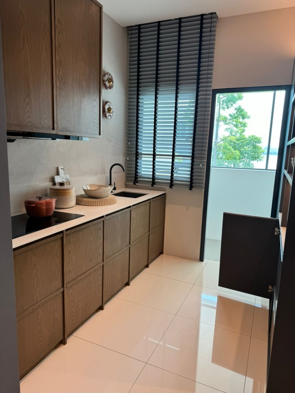 Foto show unit SkyRia: dapur dengan kabinet kayu dan pintu ke ruang yard
