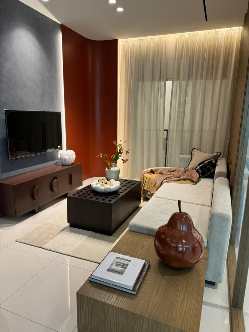 Foto show unit SkyRia: ruang tamu dengan sofa, meja kopi dan kabinet TV berhias