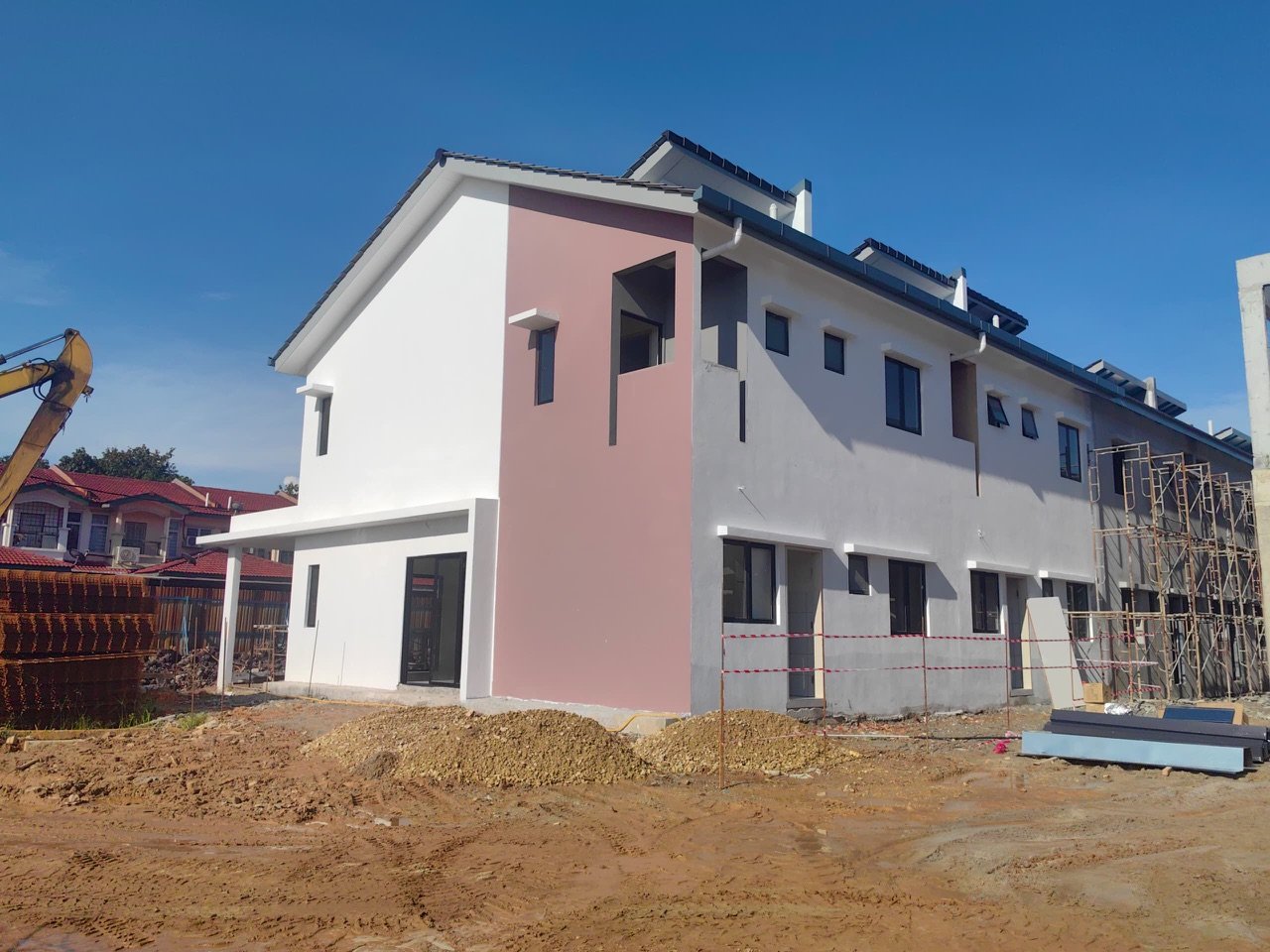 Foto sebenar rumah teres dua tingkat Taman Desa Permai dalam peringkat akhir pembinaan, dinding putih dan merah jambu